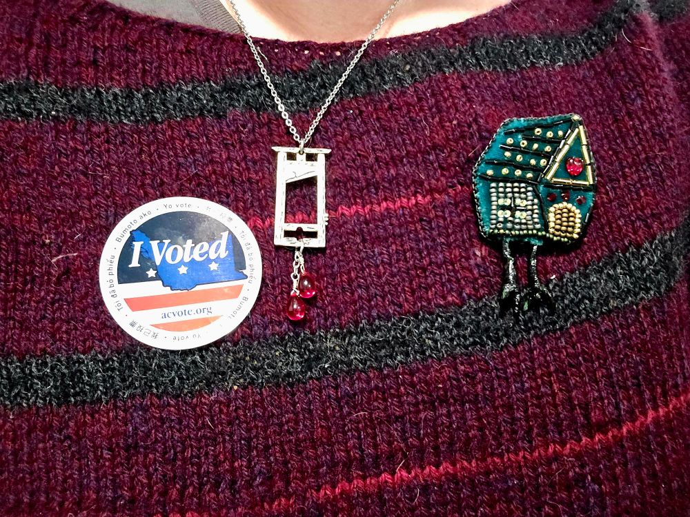 Alameda County I voted sticker with a guillotine pendant and Baba Yaga chicken house pin 
