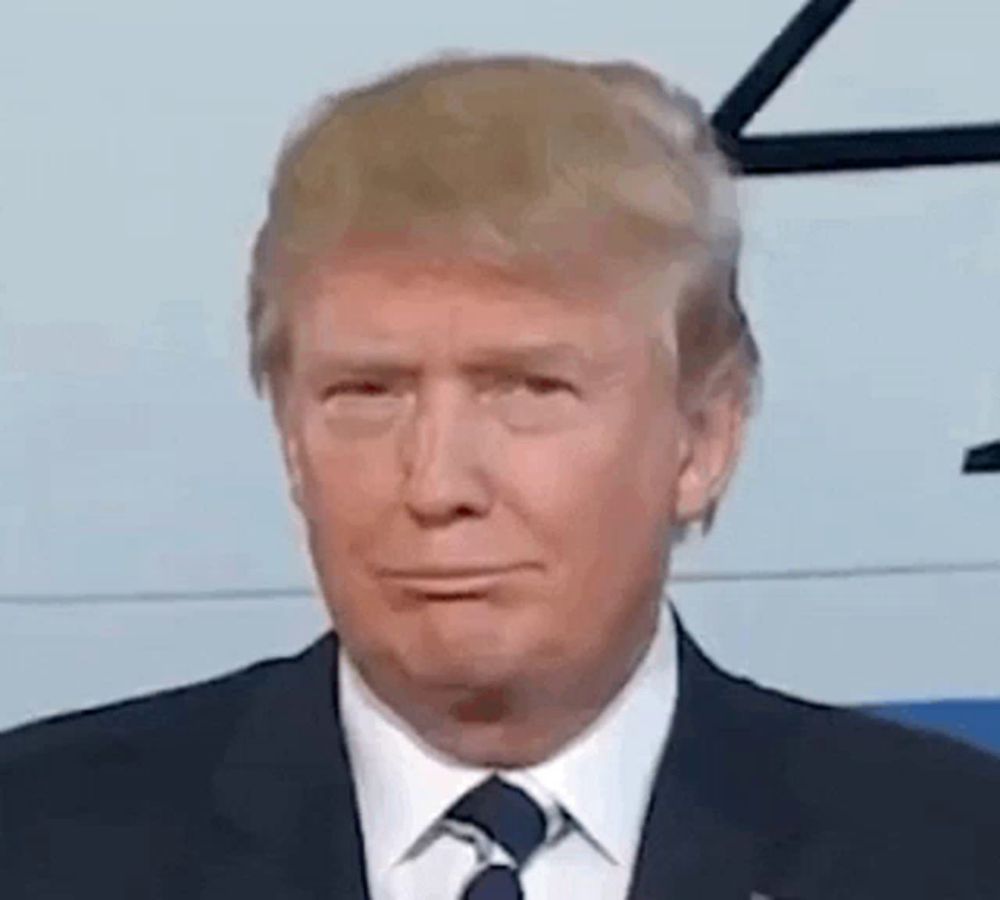 donald trump is wearing a suit and tie while making a funny face .