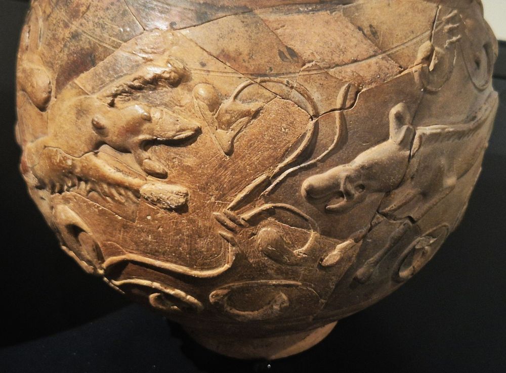 Reliefverzierung auf einem großen Tonbecher zeigt den Kampf zwischen zwei wilden tieren, begleitet von pflanzlicher Ornamentik
