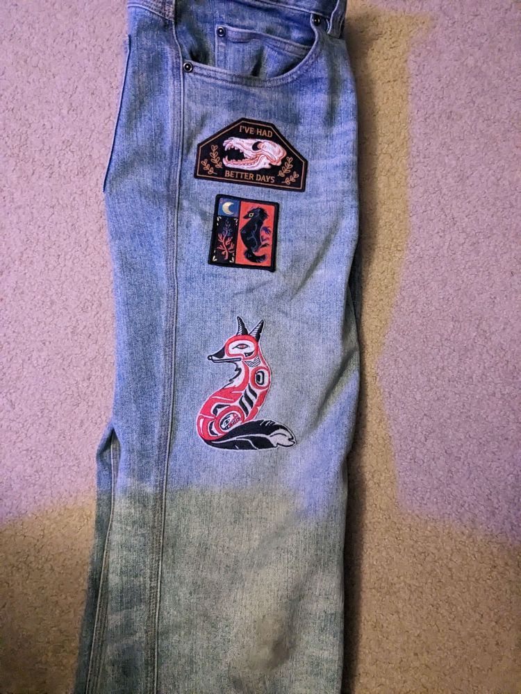 several patches of doggish critters sewn onto a pair of jeans