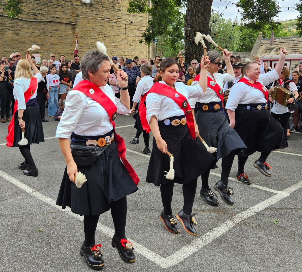 Morris dancers wearing clogs & waving ropes on sticks.