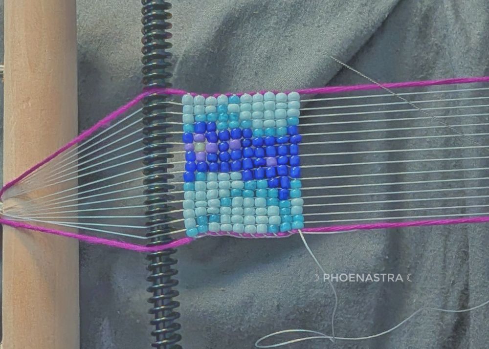 Blue and purple beads on a loom 