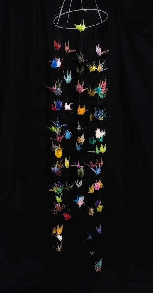 bramakumaris listed as creator of installation - multicolored folded paper bird mobile, long vertical strands on a wire frame