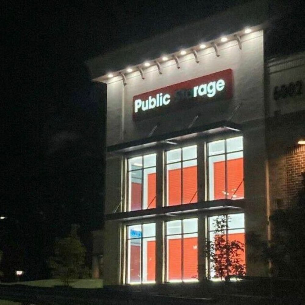 Sign on public storage building with lights burnt out in several letters, leaving “Public rage.”