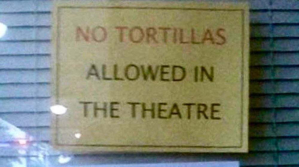 Sign on a wall reads “NO TORTILLAS ALLOWED IN THE THEATRE.”