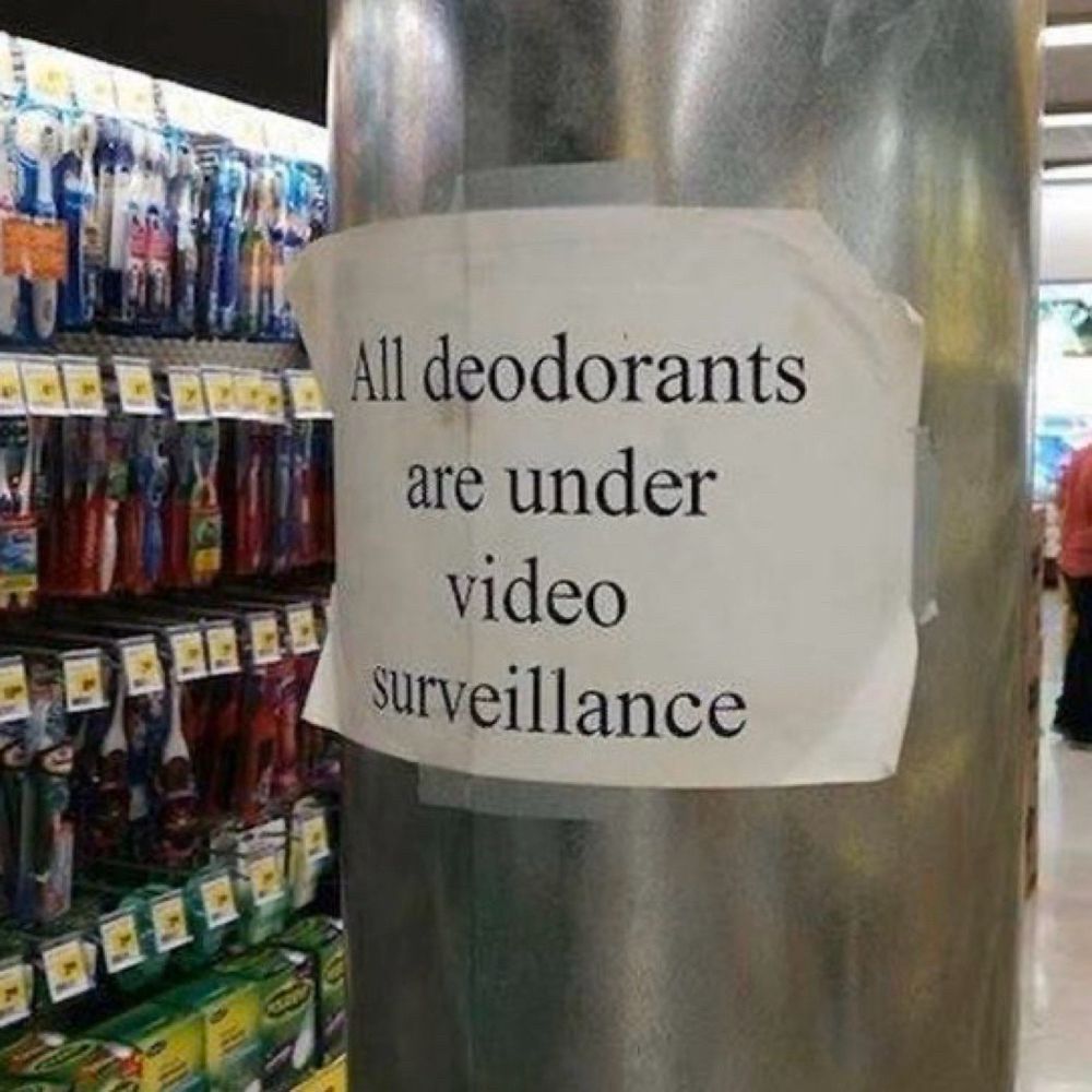 Sign next to supermarket shelves reads “all deodorants are under video surveillance.”