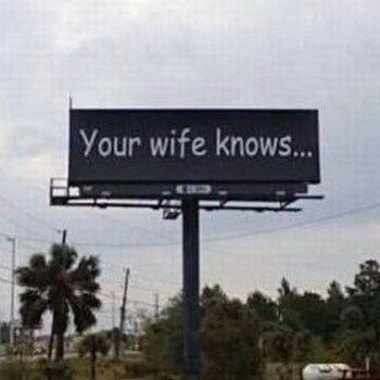 A roadside billboard reads “Your wife knows...”