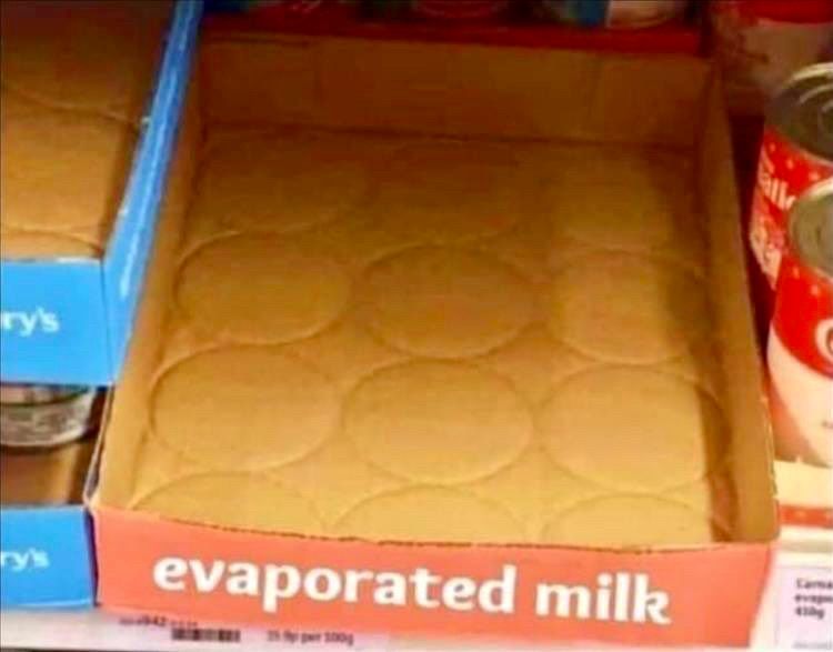 Empty cardboard tray on a market shelf labeled “evaporated milk.”