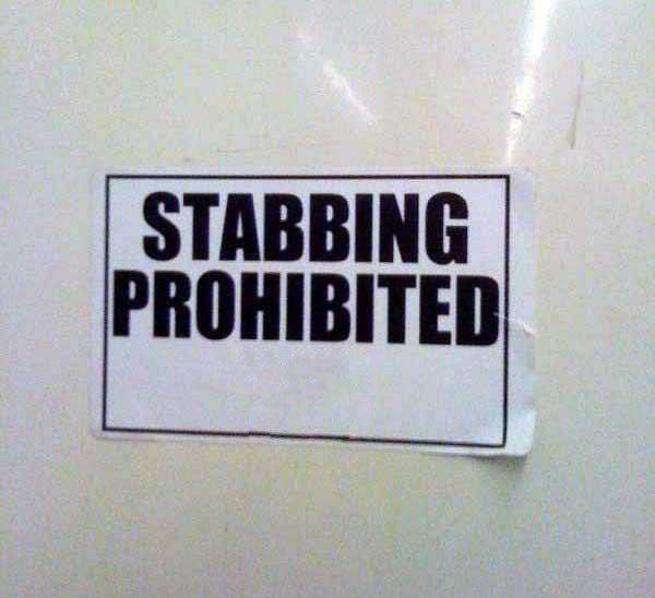 Sign taped to wall reads "STABBING PROHIBITED" in bold black lettering.