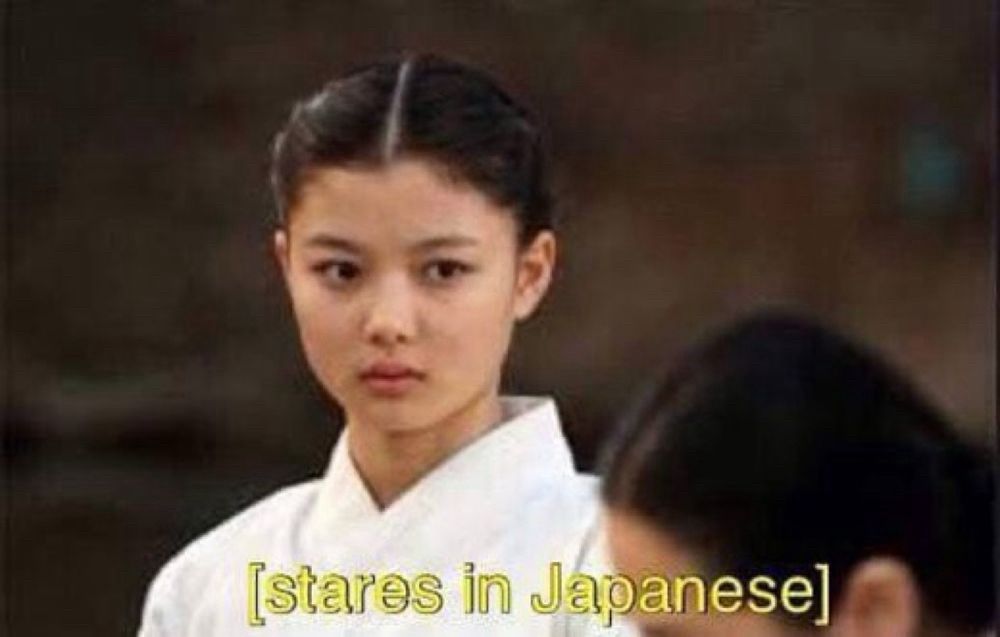A Korean actress in traditional attire looks intently at someone off-screen. The image features a caption that states "[stares in Japanese]."