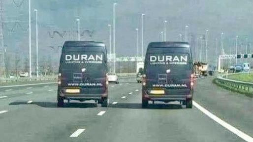 two vans branded DURAN drive next to each other on a highway