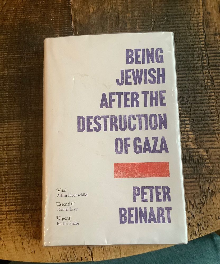 picture of the hardback book “Being Jewish After The Destruction of Gaza” by Peter Beinart on a wooden table.