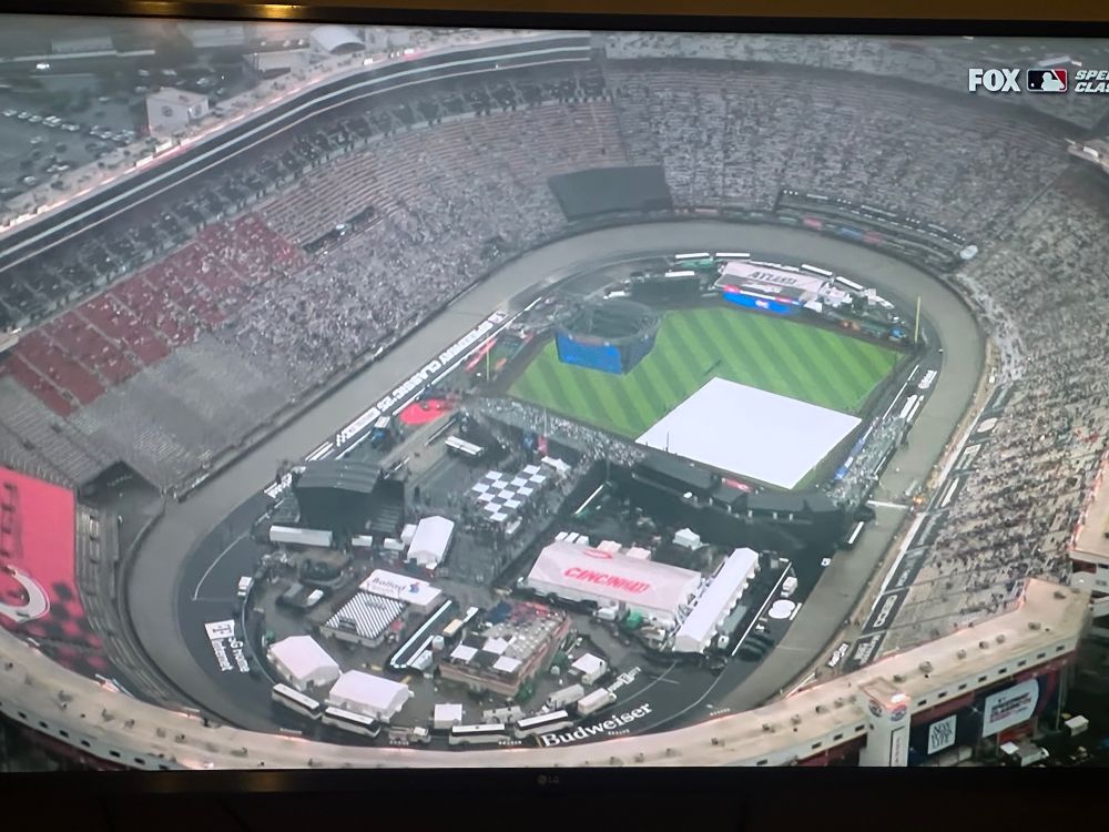 A baseball game being held at a NASCAR track is in a rain delay 