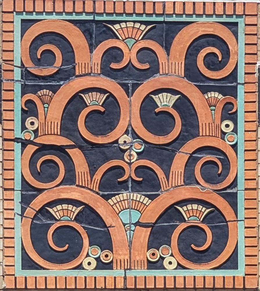 an art deco design on the top of a building in Chicago, orange and turquoise with fan designs