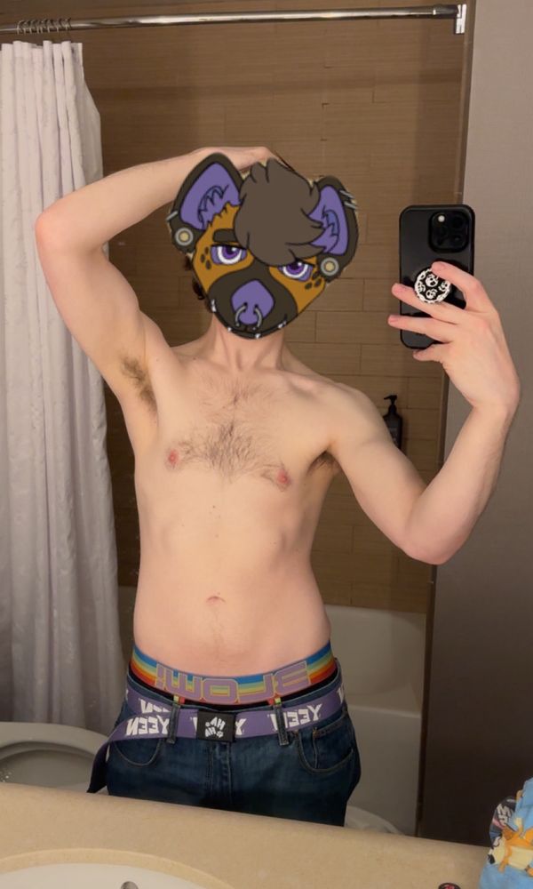 A photo of a shirtless cis male with an anthro furry hyena yeen face covering the head