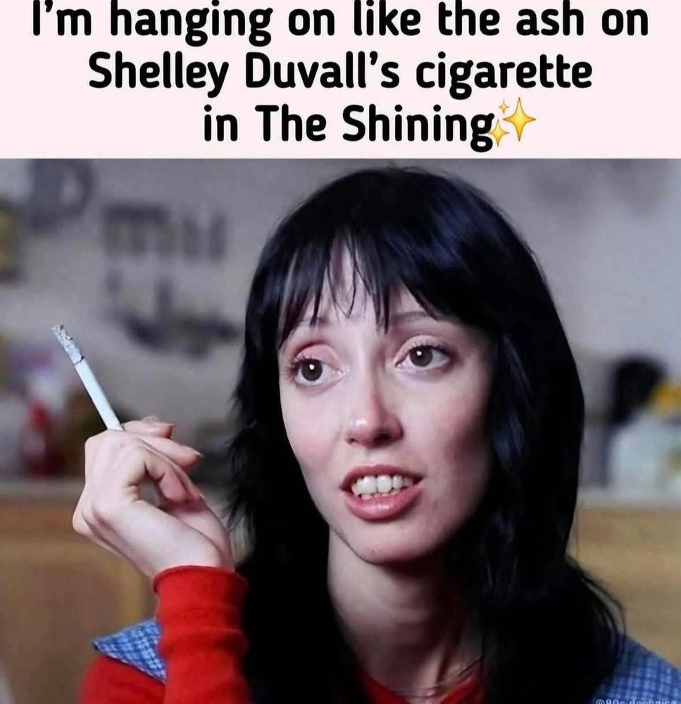 Photo of Shelley Duvall in the movie “The Shining.” 

She is holding a cigarette and the ash on the cigarette is very long.  This suggests she was sitting still enough for a long time, and the ash had not fallen off. 
