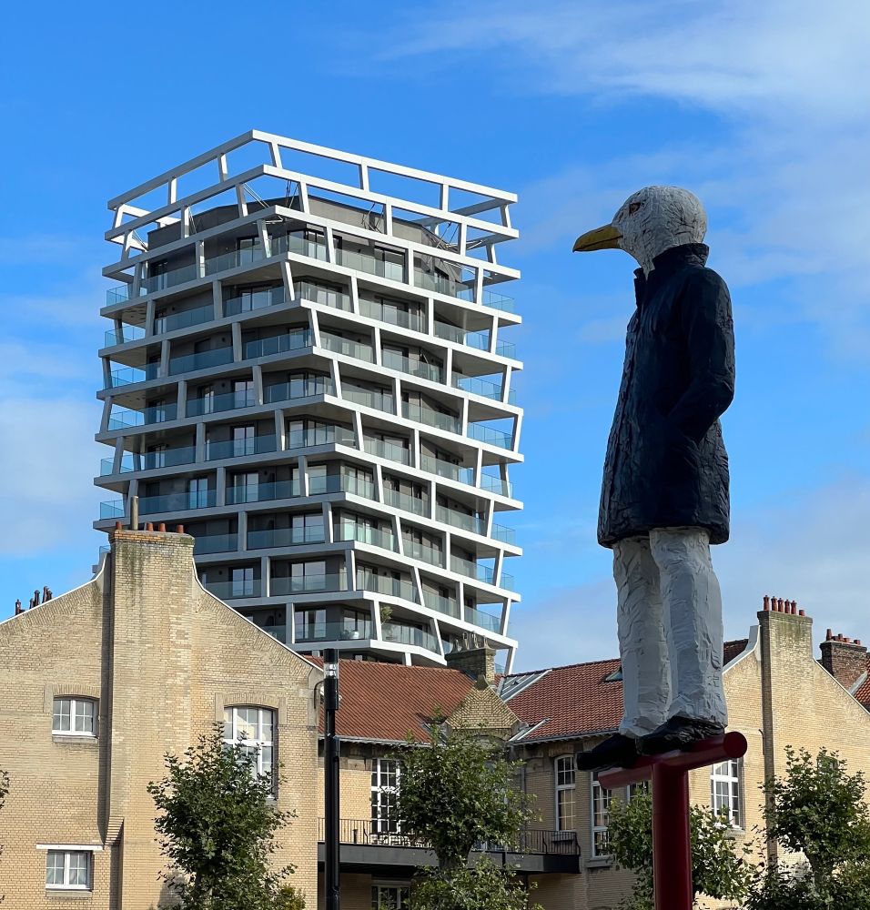 A unique apartment building in Le Havre, with a statue of a seagull wearing a peacoat in the foreground.