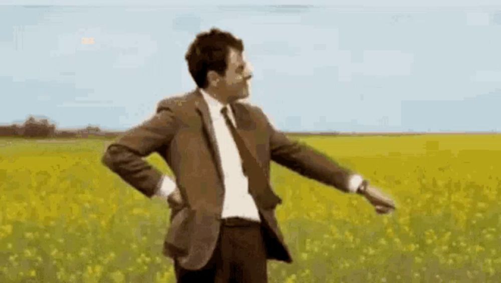 mr bean is dancing in a field of yellow flowers .