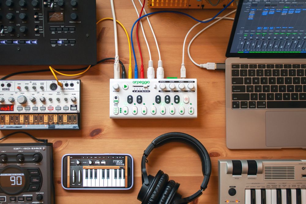 Arpeggio on a table surrounded and connected to other electronic musical instruments.