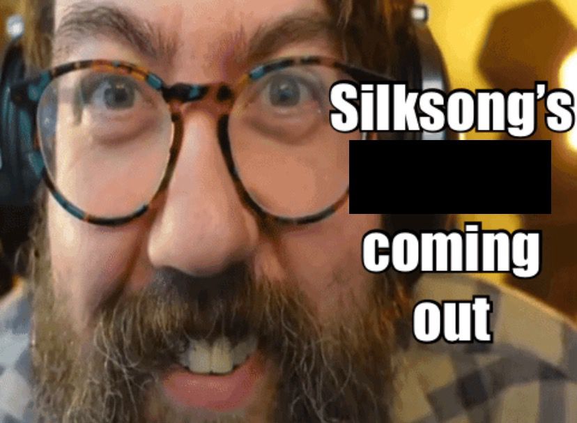 john warren with his face near the camera with the text “Silksong’s coming out” next to his face. there is a black square covering up a word, don’t worry about what it is it’s fine promise