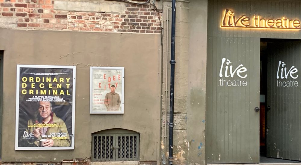 Picture of wall of Live Theatre Newcastle, one end is large workyard type gates and ‘live theatre’ in neon. Two posters one of your eponymous tweeter, Mark Thomas in Ordinary Decent Criminal. The second smaller poster is of a new monologue coming in September featuring a Sleaford Mod. 