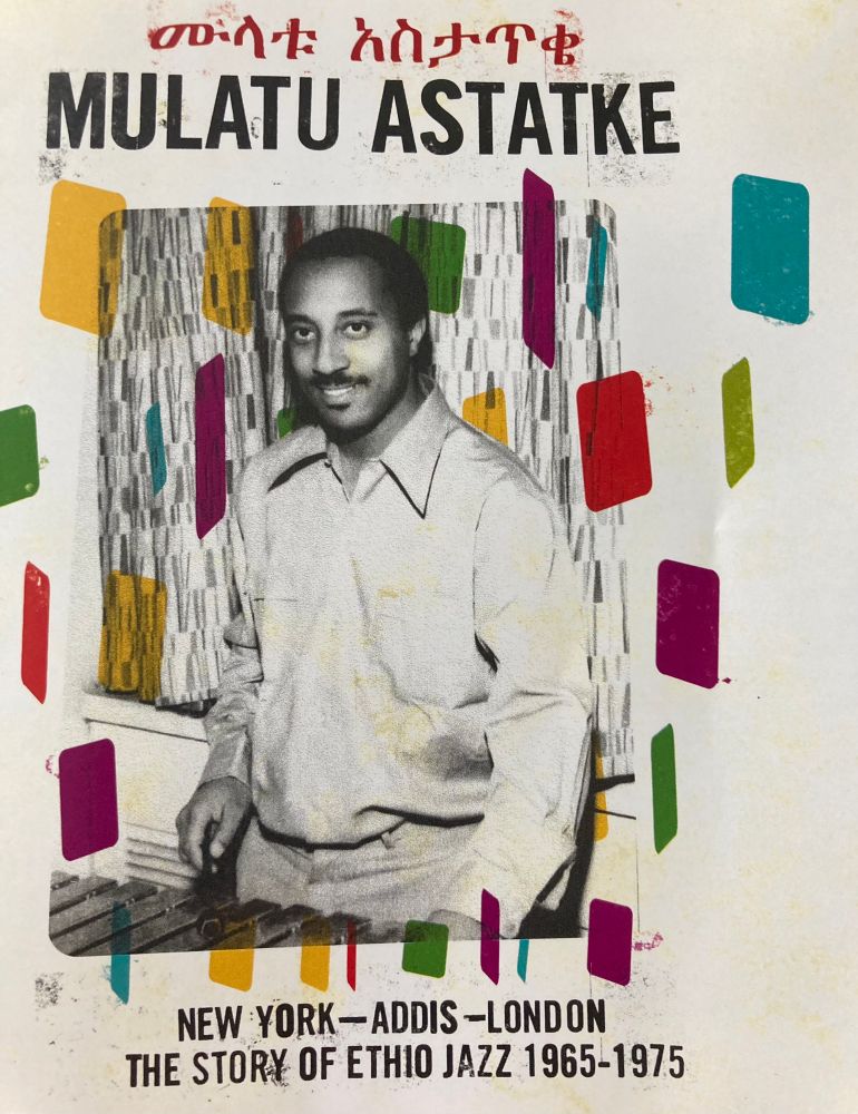 Album cover of Mulatu Astatke - The Story of Ethio Jazz 1965-1975. A white cover with gorgeous pales blocks of colour like a flying pack of cards in different shades. And in the middle beautiful picture of Mulatu at the xylophone in black and white sometime on the 60’s. 