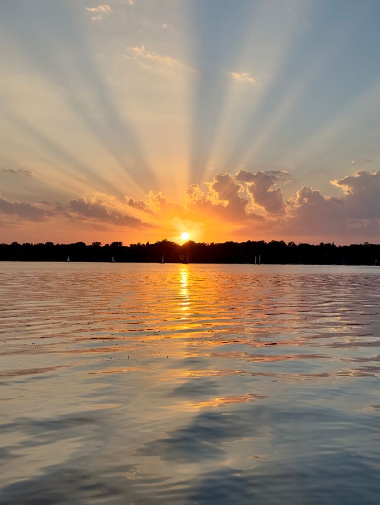 The sun sets over lake Harriet, Minnesota. Warm light.