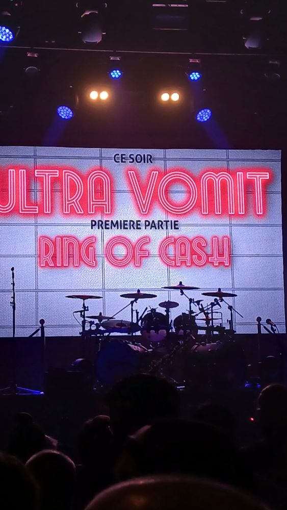 Scène de concert avec un écran affichant "Ce soir, Ultra Vomit. Première partie, Ring of Cash"