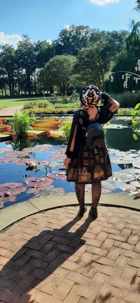 Same outfit as before, new pond, this one sporting lily pads. This photo is from the back, and you can see the ghosts on the beret and bat on their backpack. 