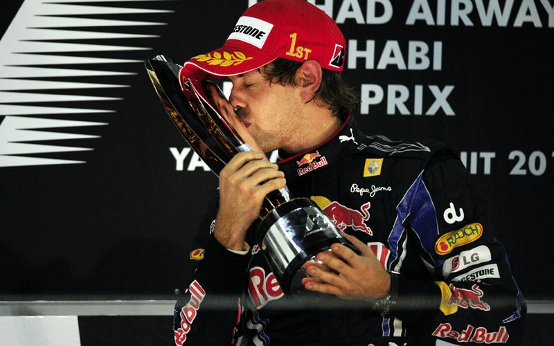 Sebastian Vettel kissing his trophy on the podium