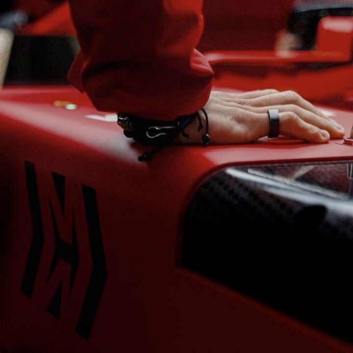 close up of charles leclerc's hand resting on his car 