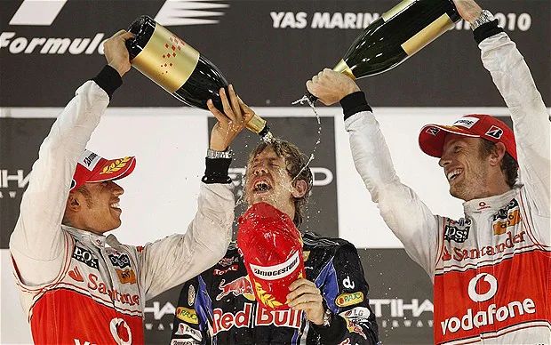 Sebastian Vettel has champagne poured on him after winning the WDC