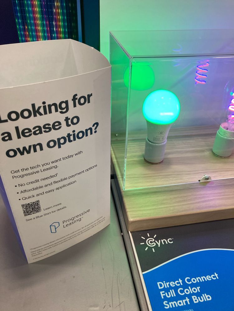 Image of a smart light bulb next to a piece of paper encouraging lease to own on electronics.