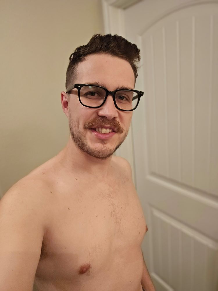 Josgar shirtless and wearing glasses.