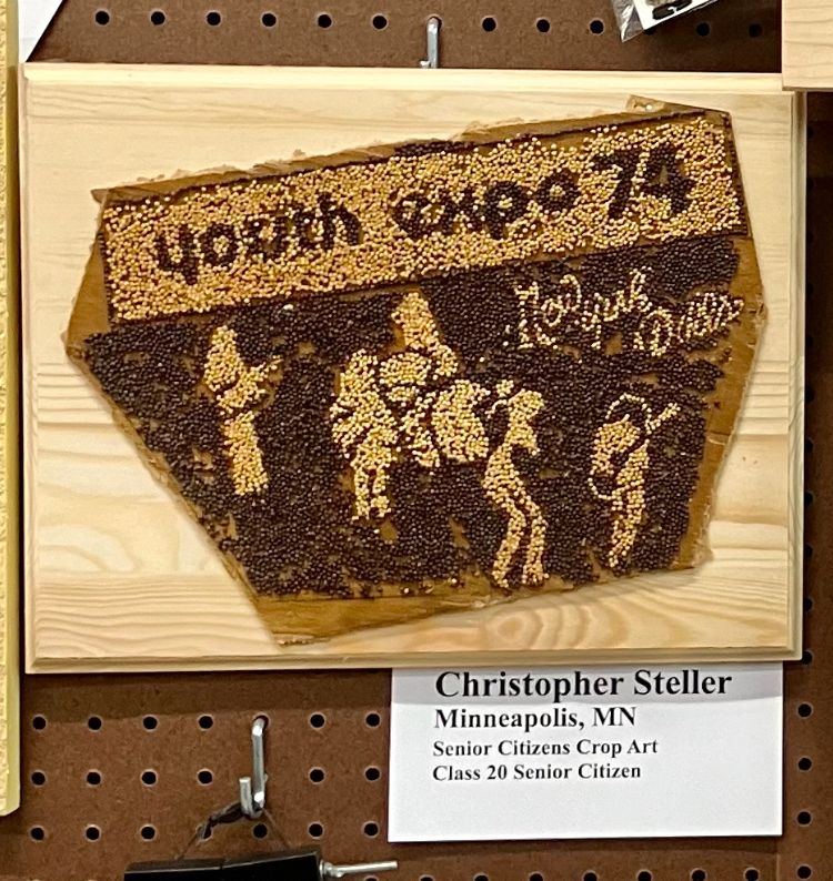 crop art in two colors of mustard seed, says Youth Expo 74 and New York Dills and there is a five-piece rock band. The card says: Christopher Steller Minneapolis, MN Senior Citizens Crop Art Class 20 Senior Citizen