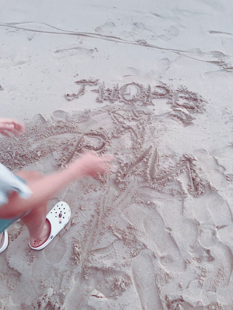 hobi drawing "J-HOPE ⭐ RM" in the sand on the beach in hawaii on bon voyage 2