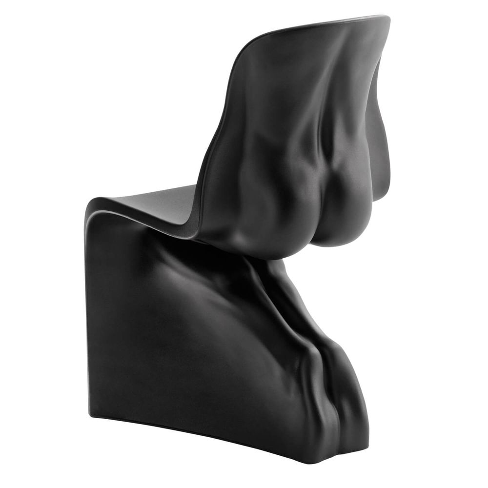 a matte black plastic chair with the back sculpted to look like a bare male torso with feet down in a kneeling position