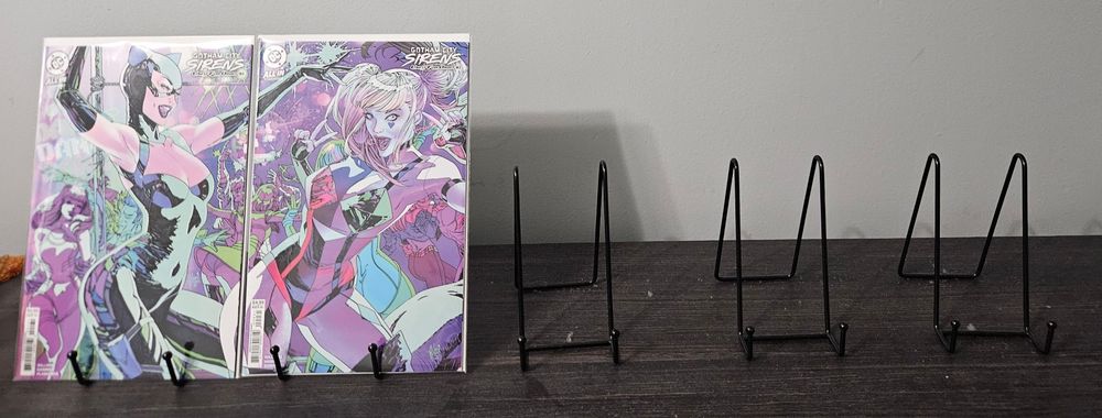 Issues 1 and 2 of Gotham City Sirens Unfit for Orbit by Leah Williams and Haining. There are 3 empty stands beside them, which will hold the remaining 3 issues to make a complete connecting cover by Guillem March 