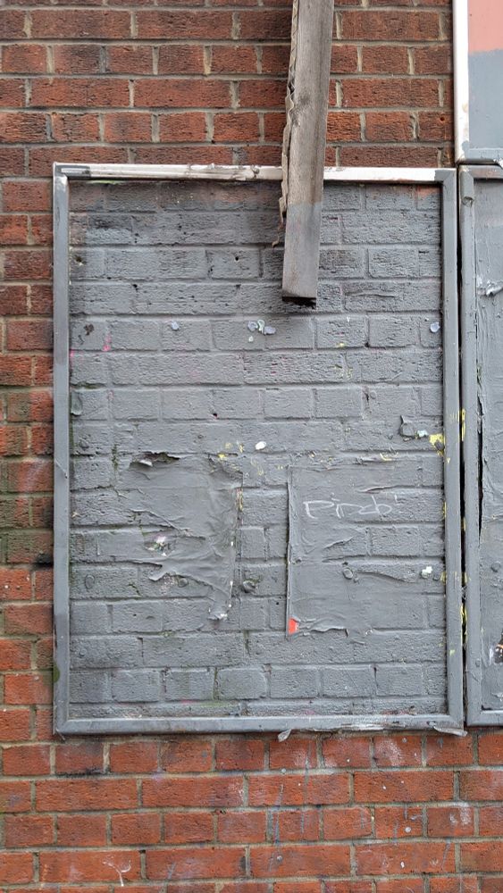 A brick wall, with a frame added to it. 
Looking broken and not used. 