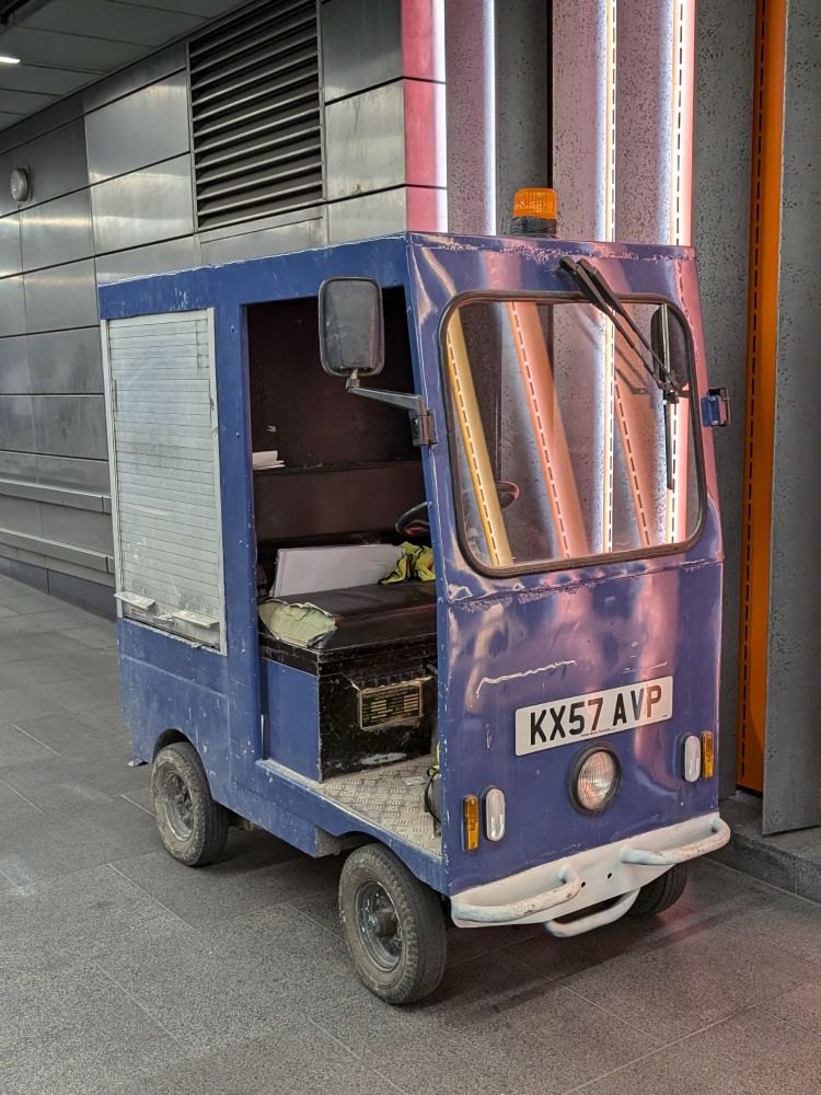A view of a small tiny car, blue and no doors. 
