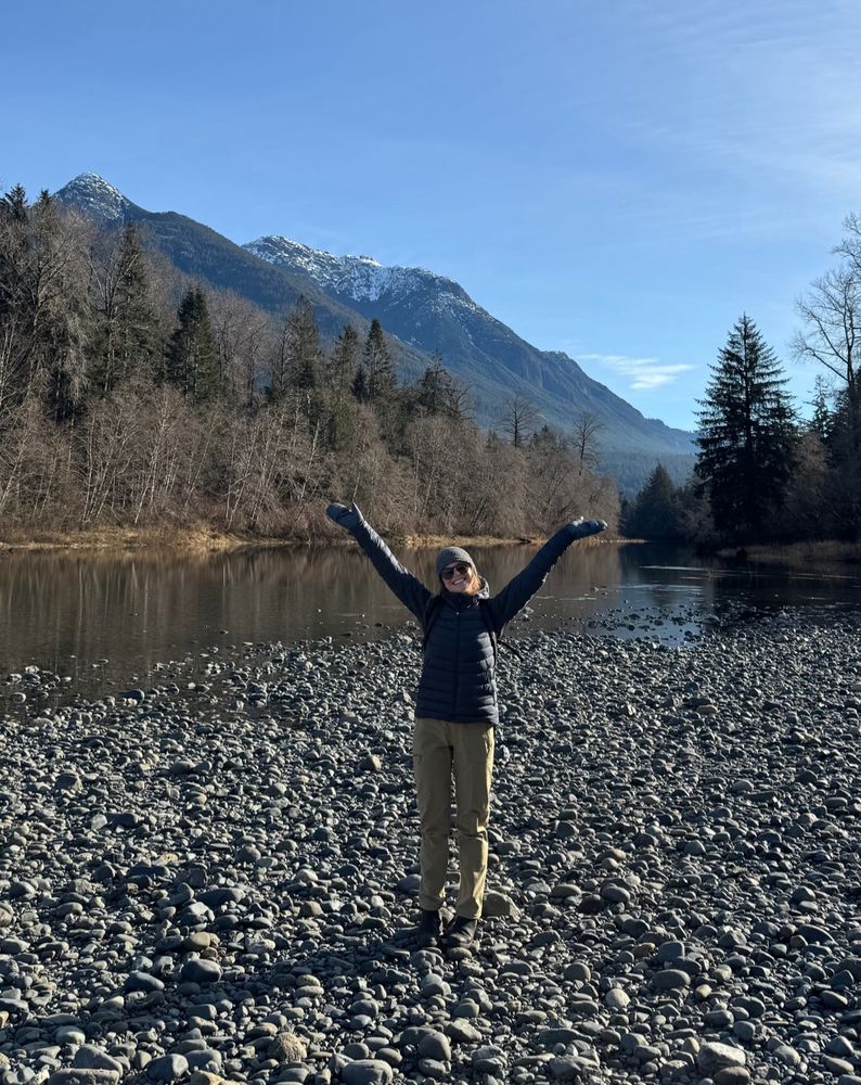 Rachael standing along a stream bank smiling 