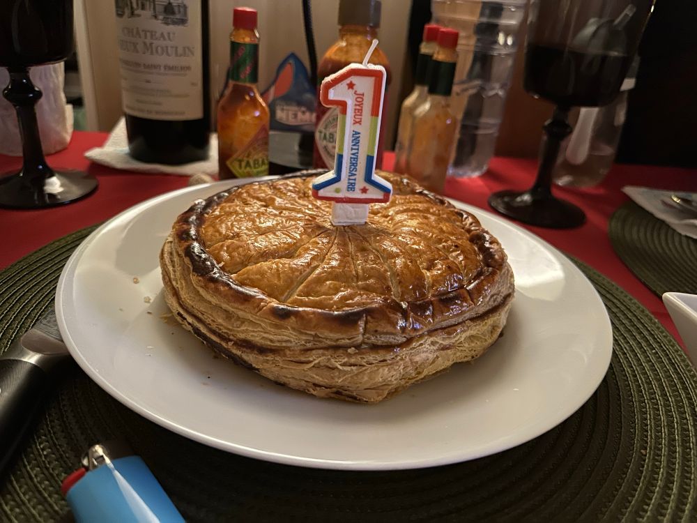 Baby’s first birthday cake is a French galette des rois or king cake. With 1st birthday candle in the center. 