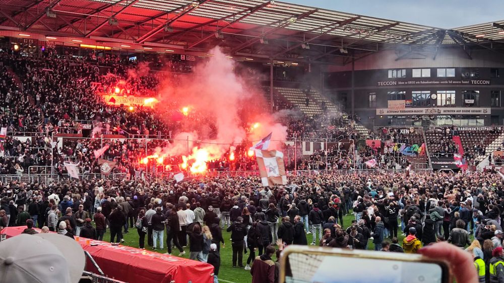 Süd mit Fans und der Mannschaft, die Pyrofackeln halten
