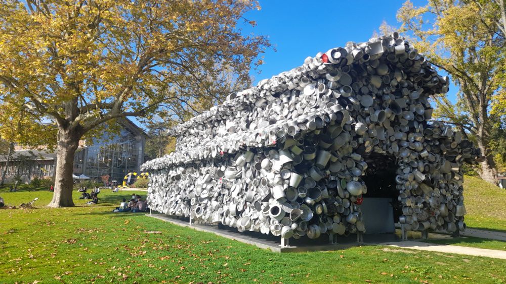 Une oeuvre d'art représentant une maison en taille réelle entièrement recouverte de casseroles...