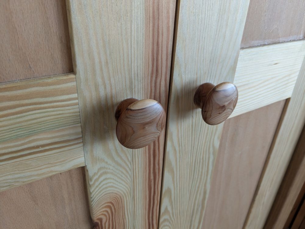 A pair of Yew wood cupboard door knobs turned for local wood to include a strip of white sap wood at the top and the patterned grain of heartwood. Seasoned yew when fine sanded is soft and smooth to the touch.