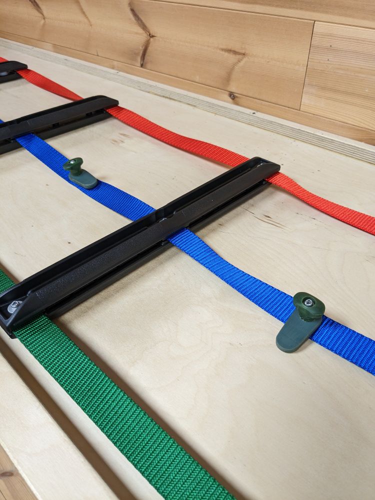 2 Rotating sail slot sliders mounted on a mast ladder in insert and lock positions to show how they work.