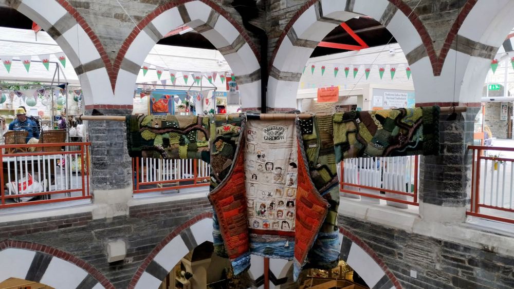 Image of giant patchwork cardigan inside the market in Cardigan, Wales.