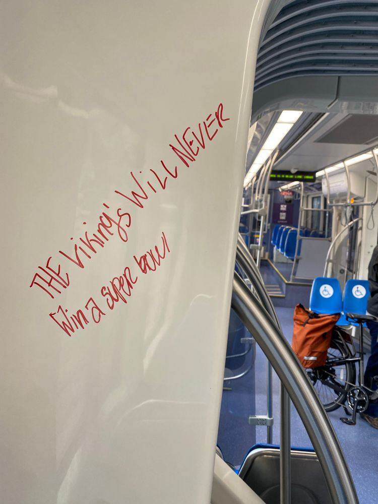 Graffiti on a METRO Blue Line train that says "The Vikings will never win a Super Bowl"