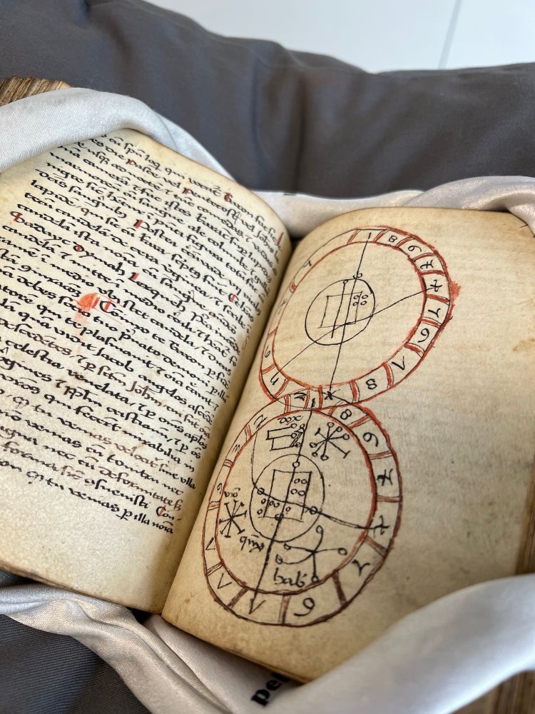 Late medieval manuscript. Left-hand page contains script and the right-hand page includes a diagram of circles and astronomical symbols