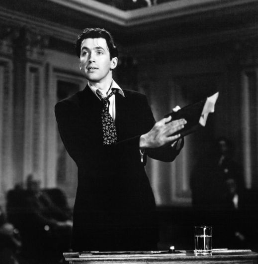 Still image from Mr. Smith Goes to Washington of a disheveled Jimmy Stewart holding a book.